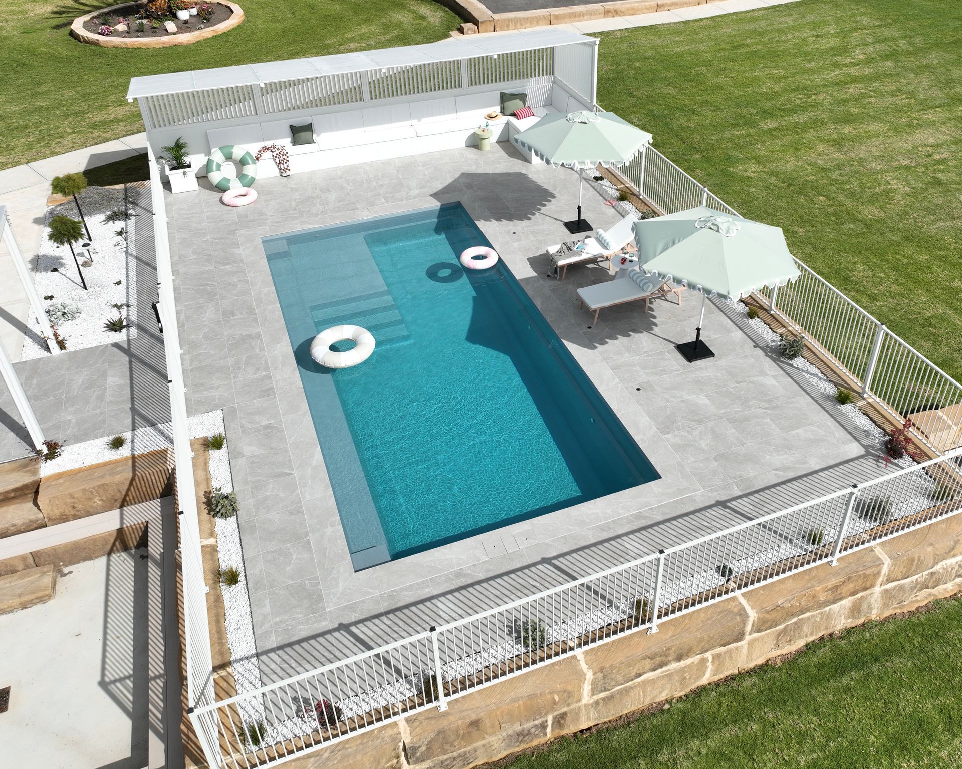 Modern Backyard Pool With Lounge Chairs, Umbrellas — Billabong Pool Co in Smeaton Grange, NSW