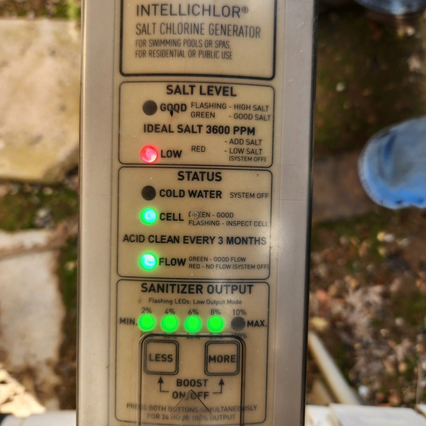 Pool salt chlorinator control panel with green status lights and low salt warning