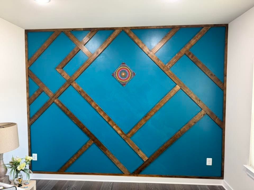Teal accent wall with diagonal wood trim and a small decorative medallion in the center