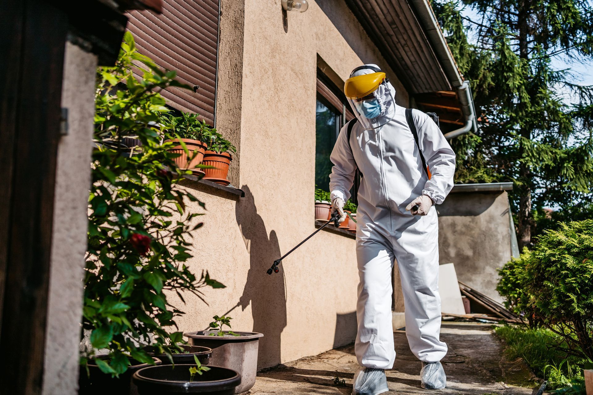 A man in a protective suit providing Pest Control Services Rochester Hills Mi 