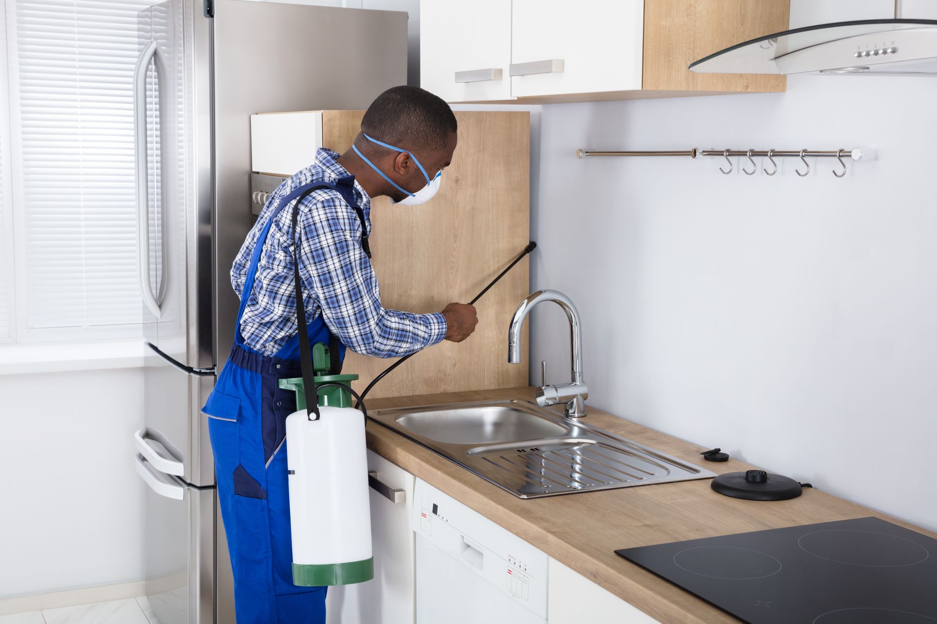 Worker spraying pesticide with sprayer.