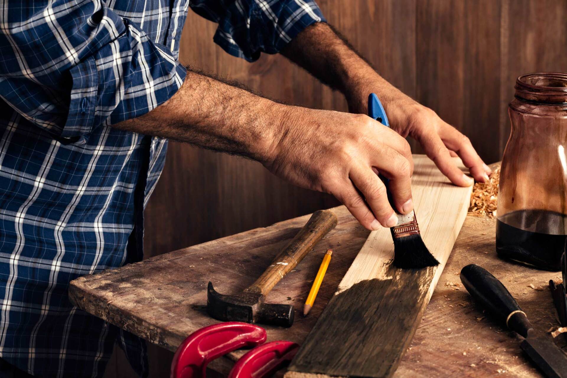 Male Carpenter Stain Dying Lumber Plank In Home Workshop - Warren, MI - Maple Lane Pest Control Male Carpenter Stain Dying Lumber Plank In Home Workshop - Warren, MI - Maple Lane Pest Control
