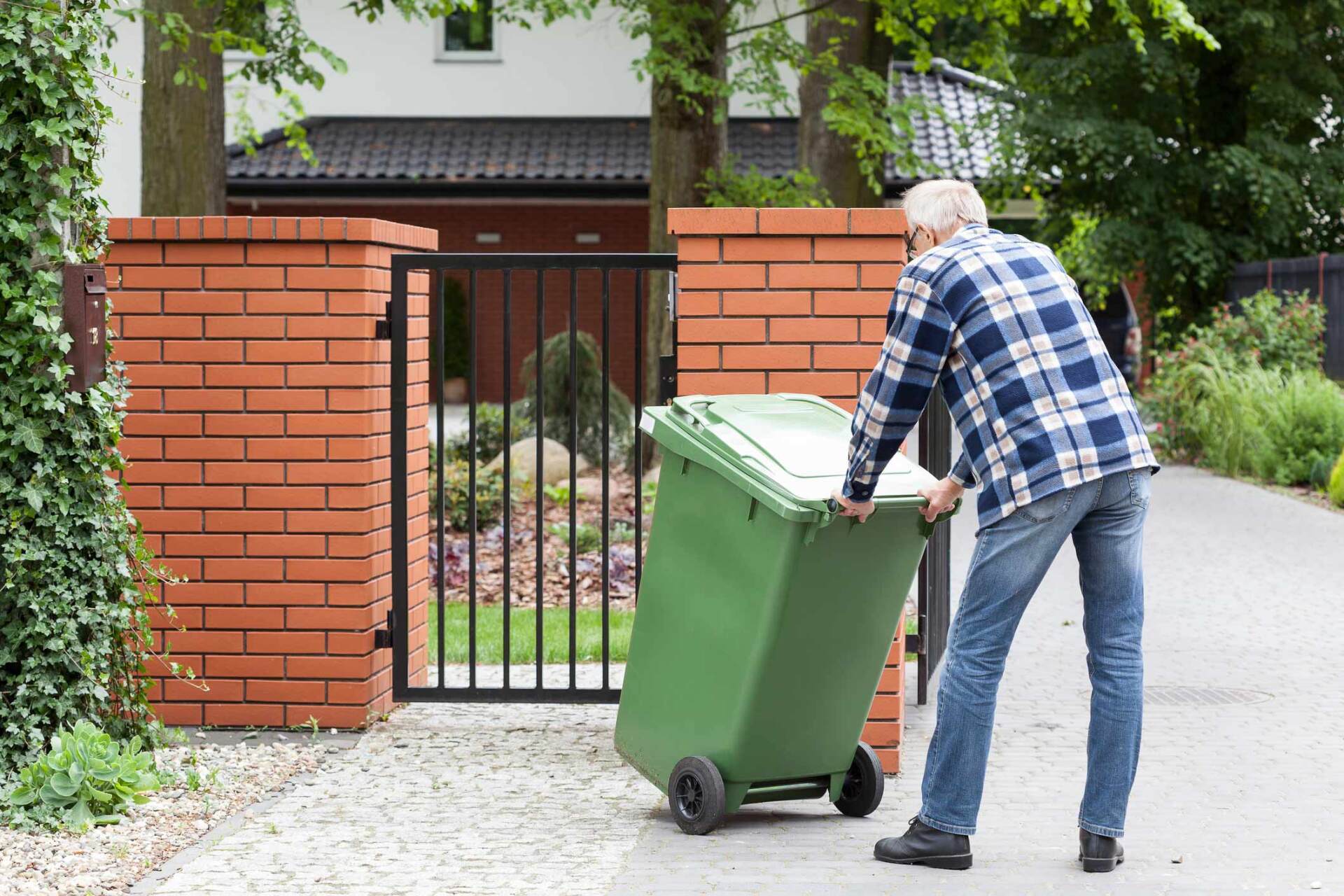 Man Is Pushing Wheeled Dumpster - Warren, MI - Maple Lane Pest Control