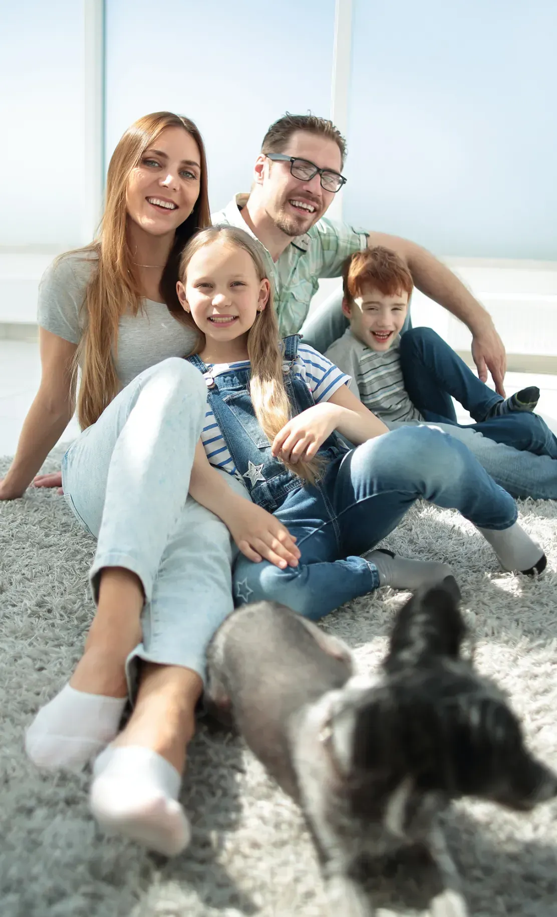 Family with their dog sitting on the living room floor, illustrating who is eligible for ACA Marketplace coverage