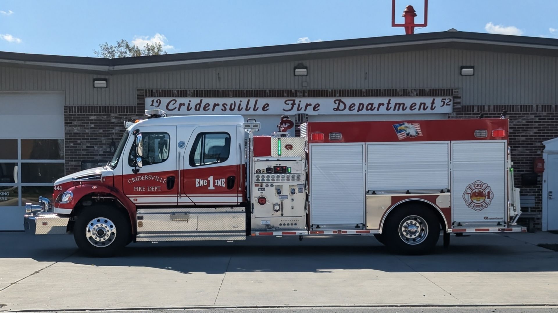 Fire truck parked in front of Cridersville Fire Department. White and red truck with equipment.