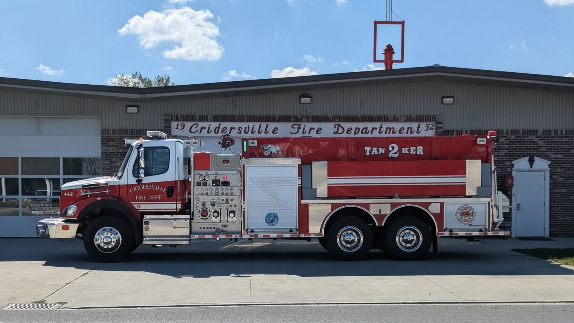 Fire truck parked at the Elderdsville Fire Department, red and white with a hose bed.