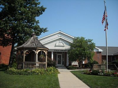 Library building with gazebo, flag, and walkway.
