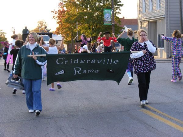 People marching in a parade, carrying a banner that says 