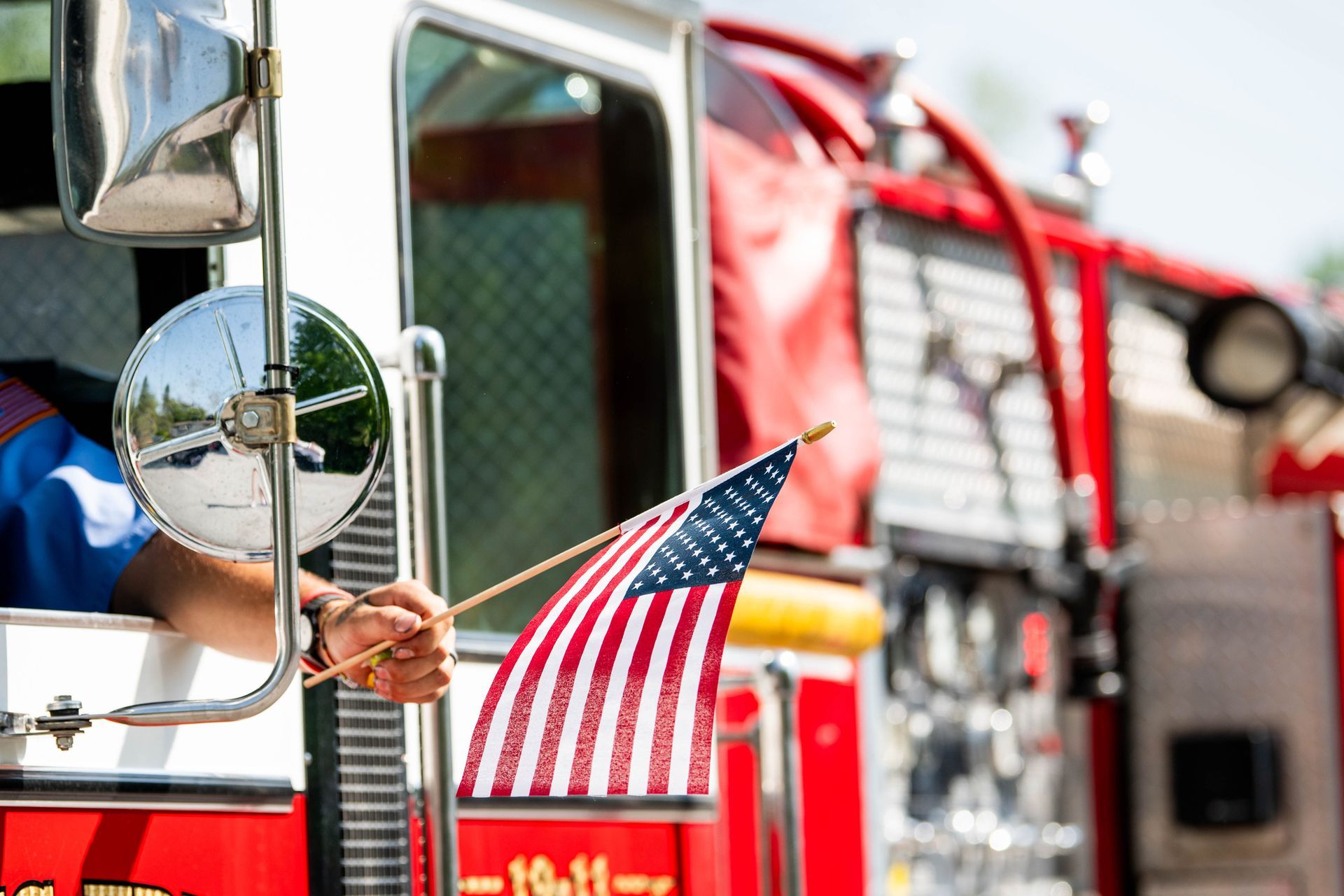 Fire truck with an American flag held out the window.