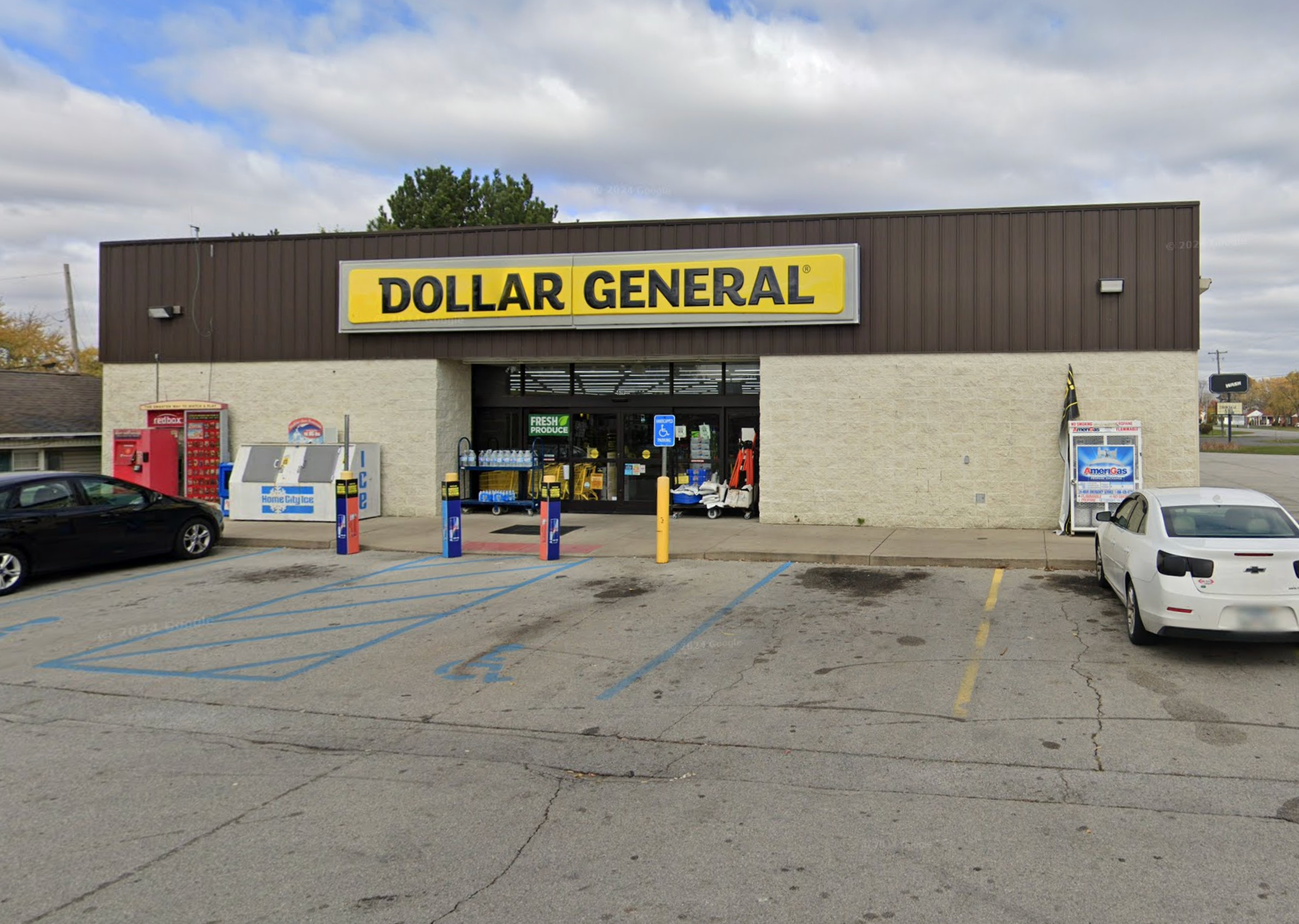 Dollar General store front with yellow sign, brick facade, and parking lot.