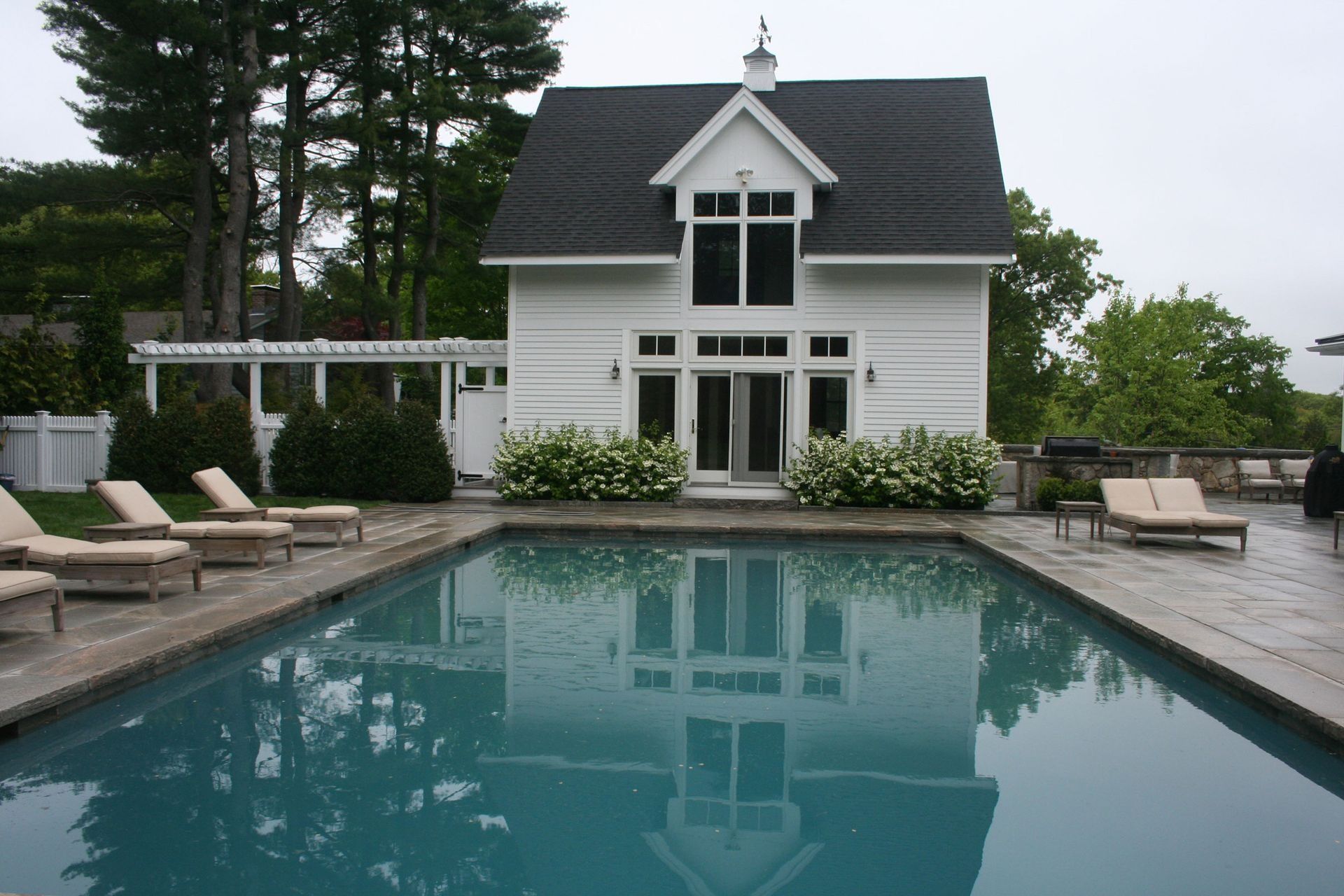Modern white house with a backyard swimming pool and lounge chairs