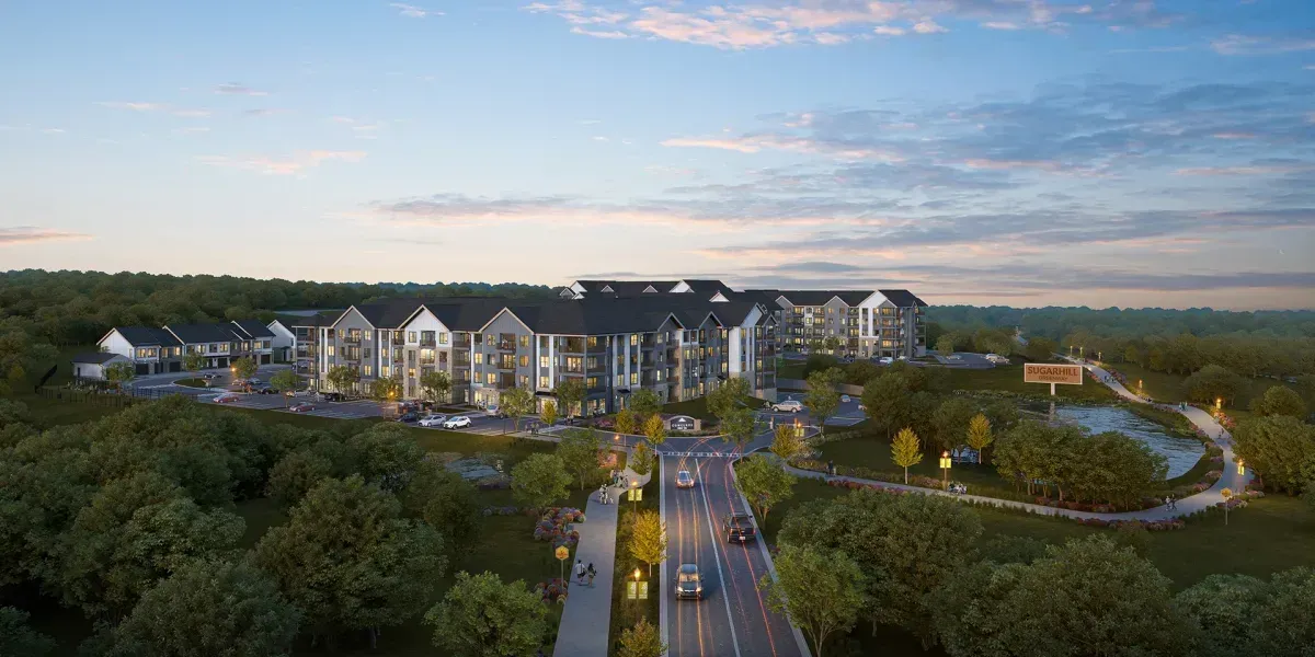 An aerial view of Conclave Sugar Hill surrounded by trees and a road.