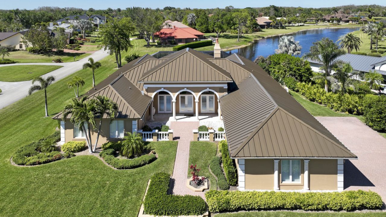Orange tiled roof with four metal vent pipes protruding from the shingles.