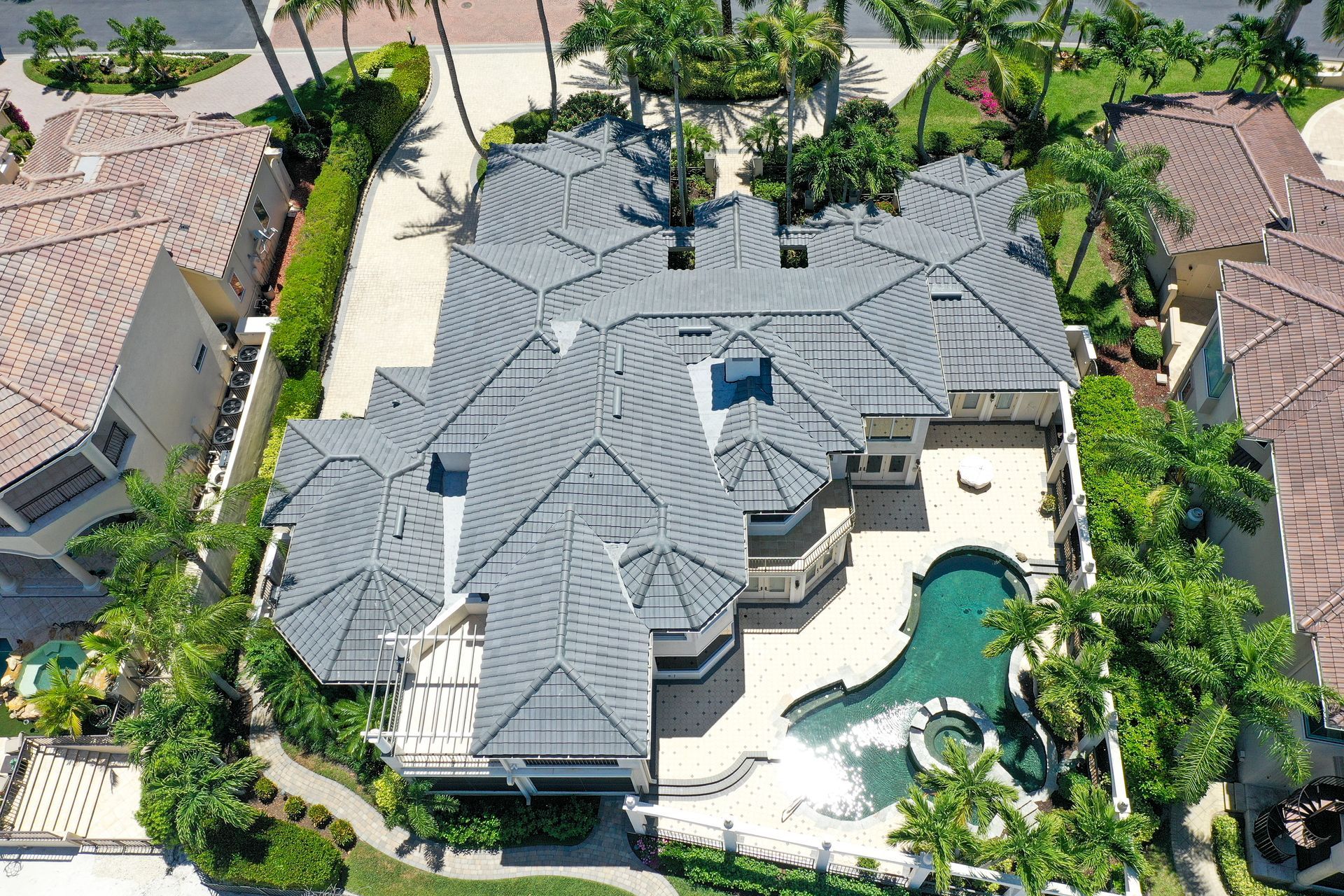 Aerial view of a modern white house with a large green lawn in a suburban area