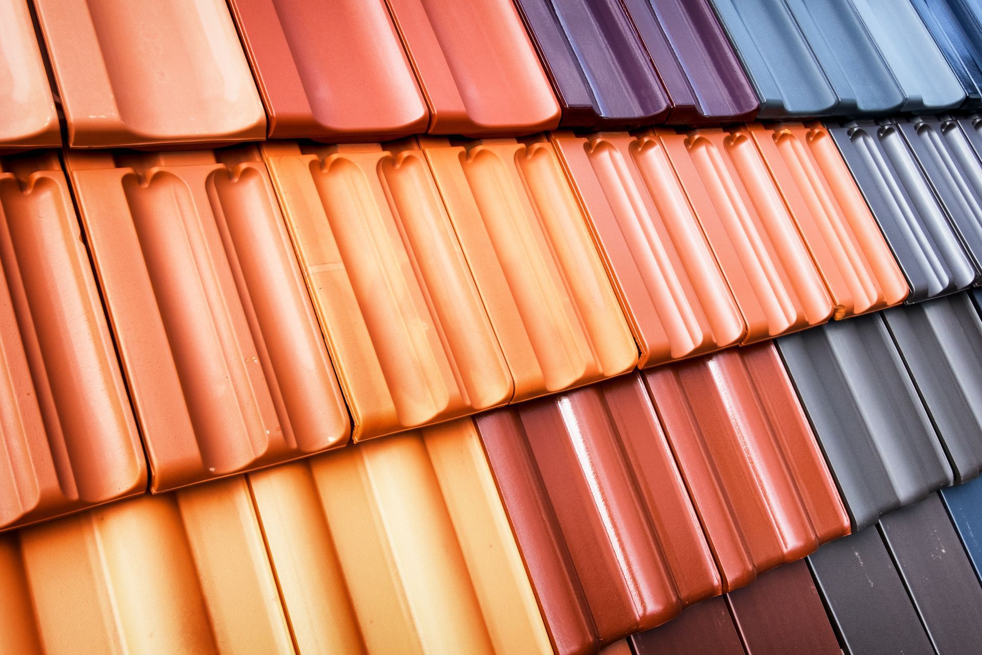 Rows of colorful clay roof tiles in orange, red, blue, and gray, arranged in a diagonal pattern