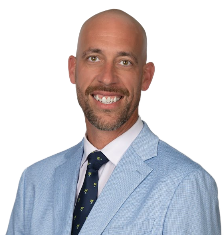 Man with glasses, bald head, and purple sweater smiling in front of white background.