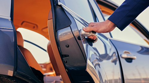 Hand opening car door. Blue car, tan interior.