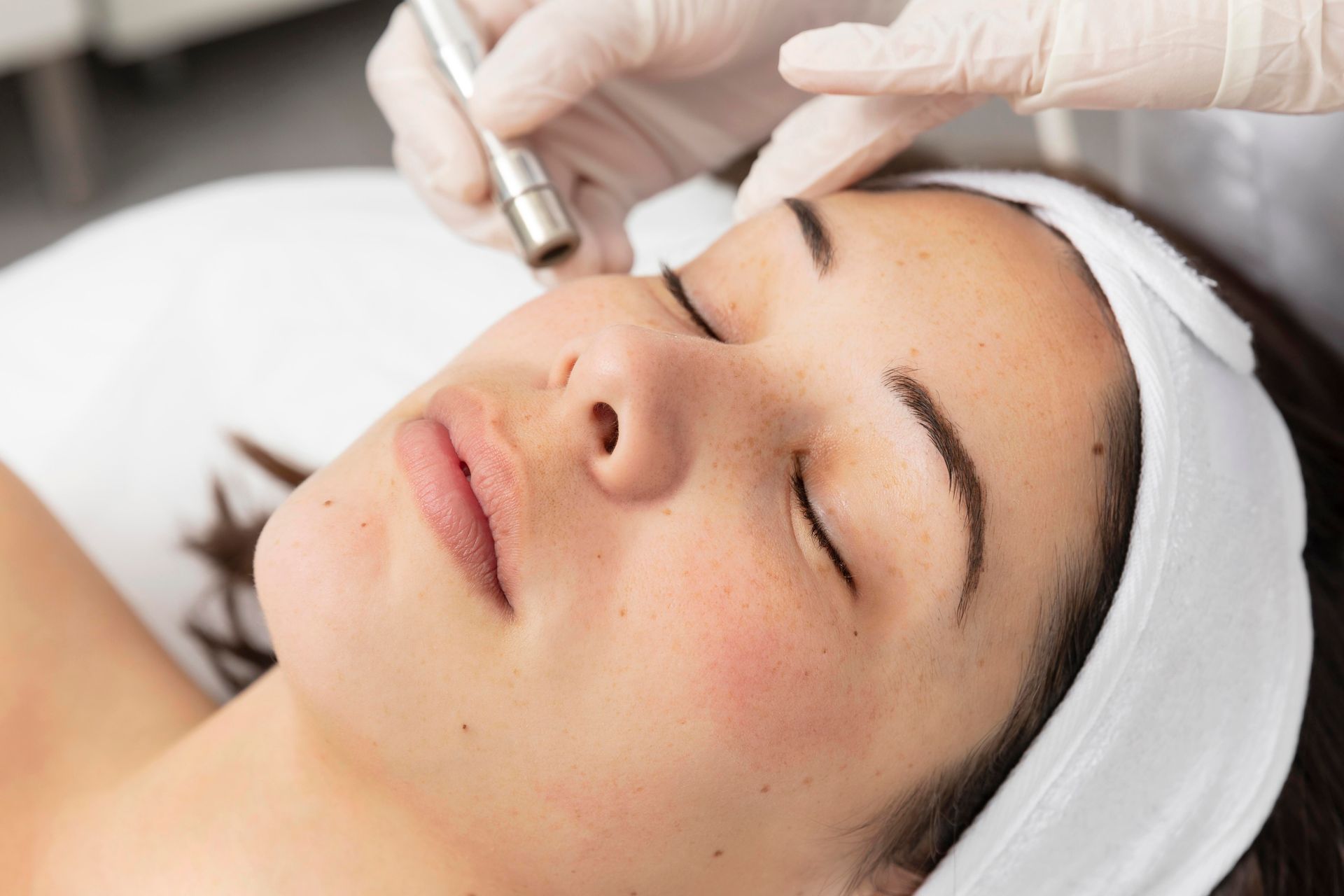 Une femme reçoit un soin du visage dans un salon de beauté.