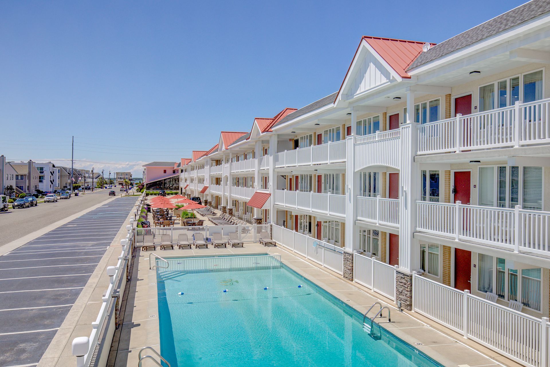 A large swimming pool surrounded by white buildings on a sunny day