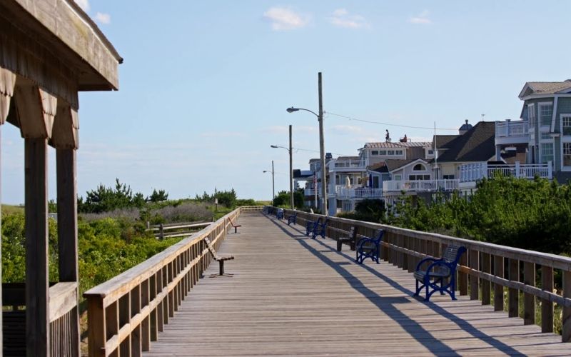 A wooden walkway leading to a beach on a cloudy day.