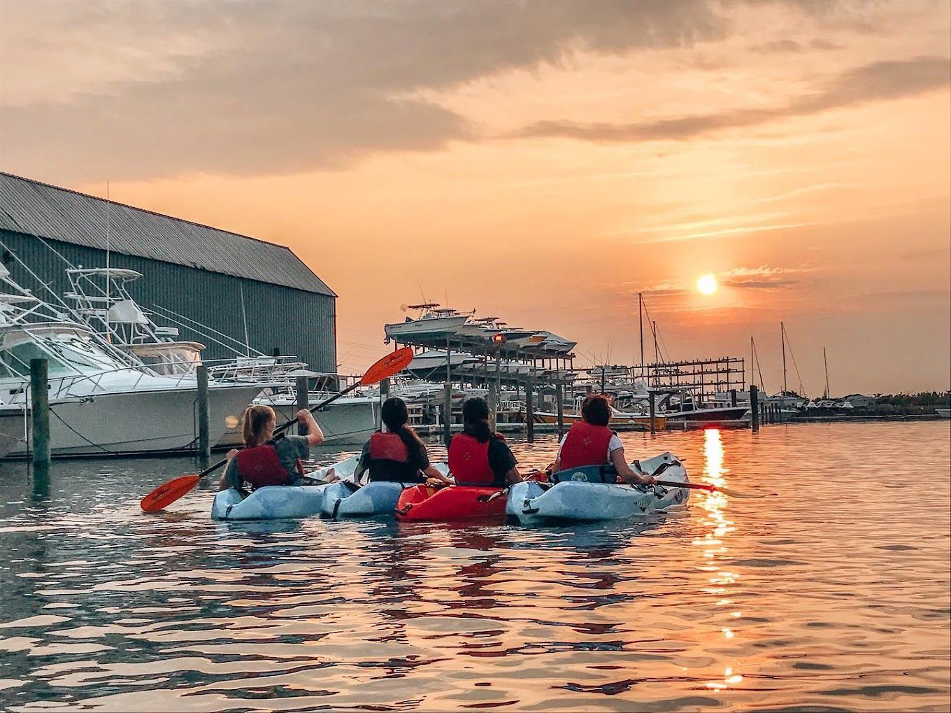 A person in an orange kayak is paddling down a river.