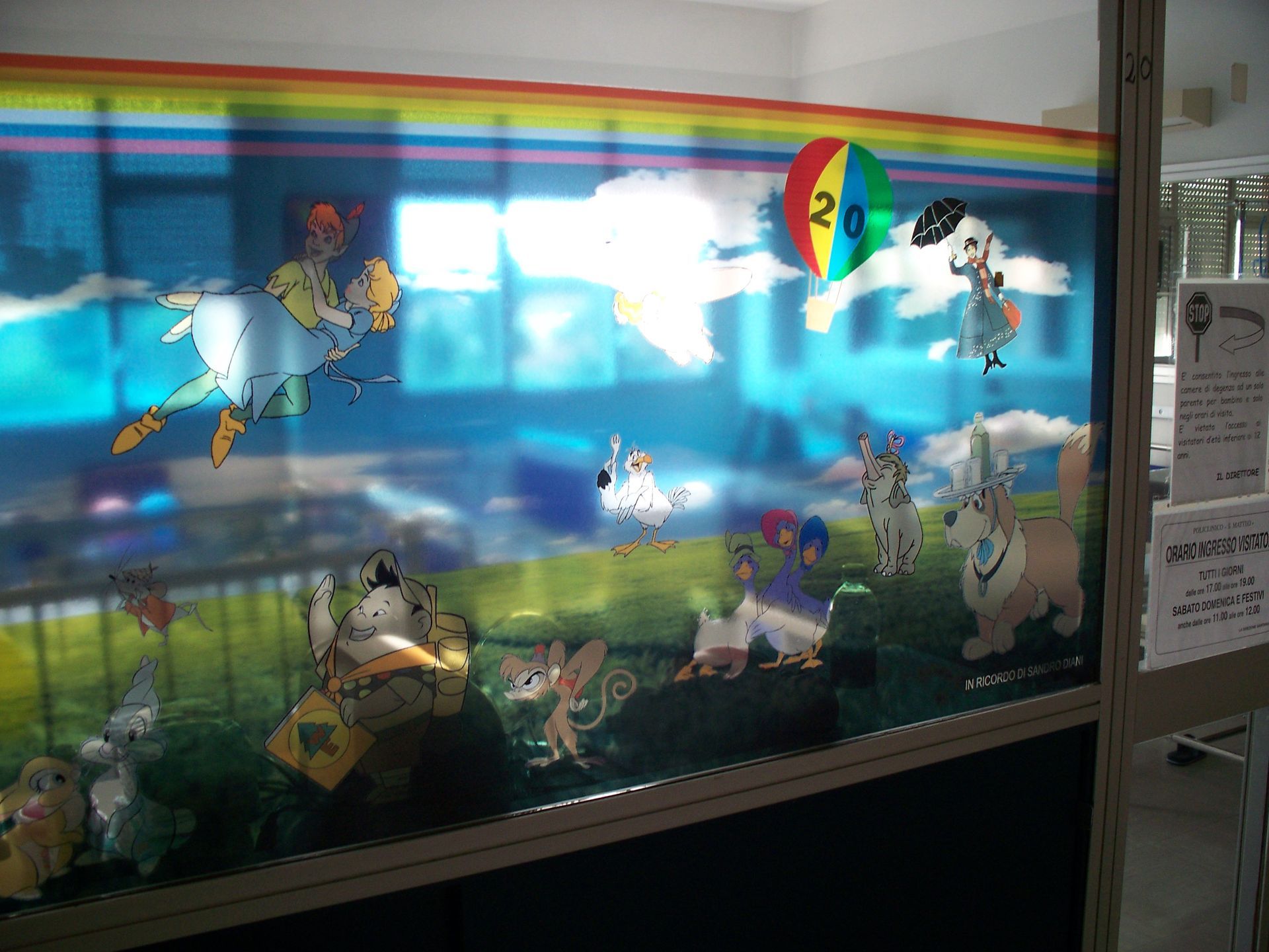Animali e personaggi dei cartoni animati colorati su uno sfondo blu con un arcobaleno.