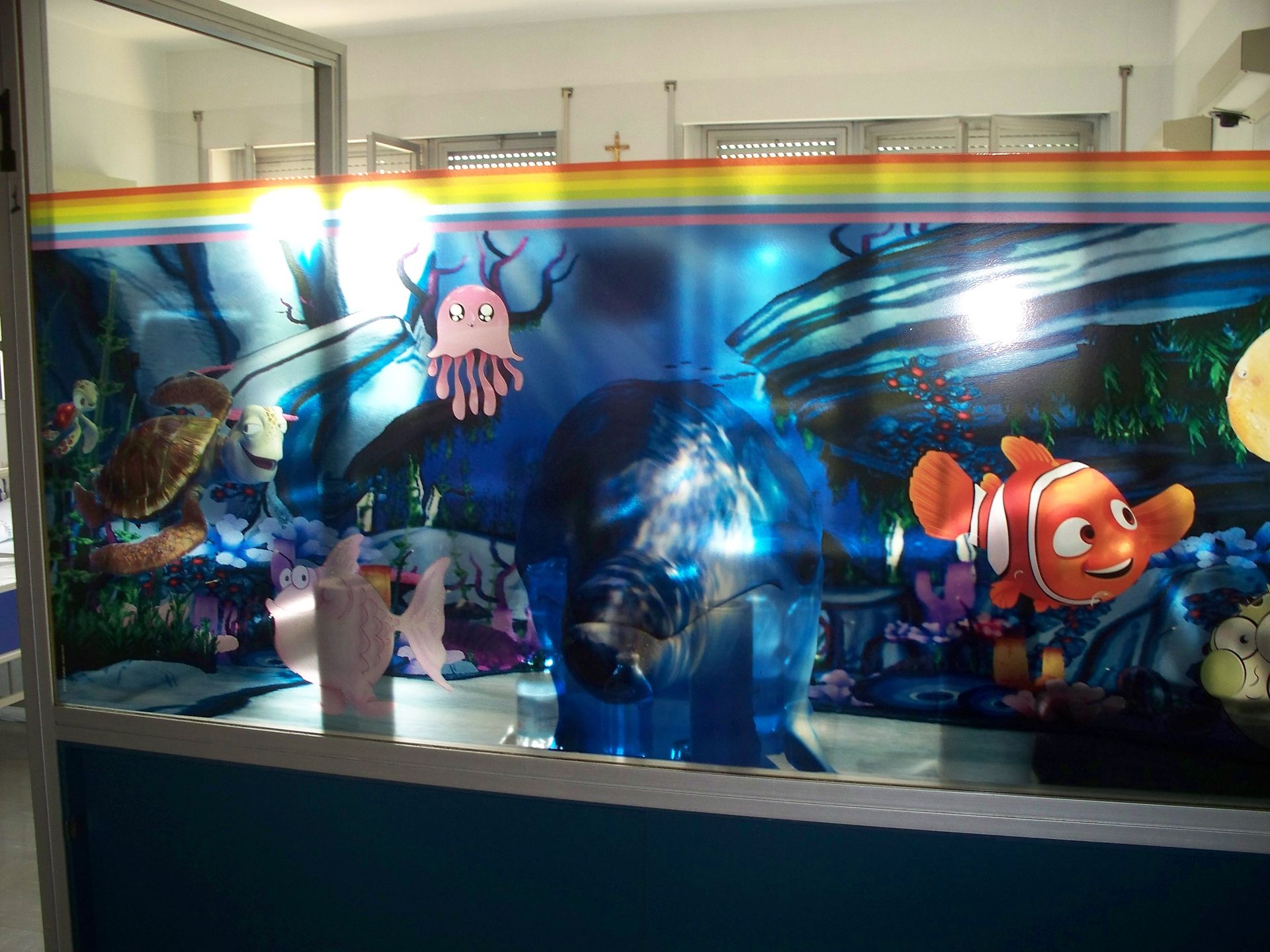Un grande murale a tema acquario con Nemo, una tartaruga e una medusa, che si estende per tutta la lunghezza di una stanza.