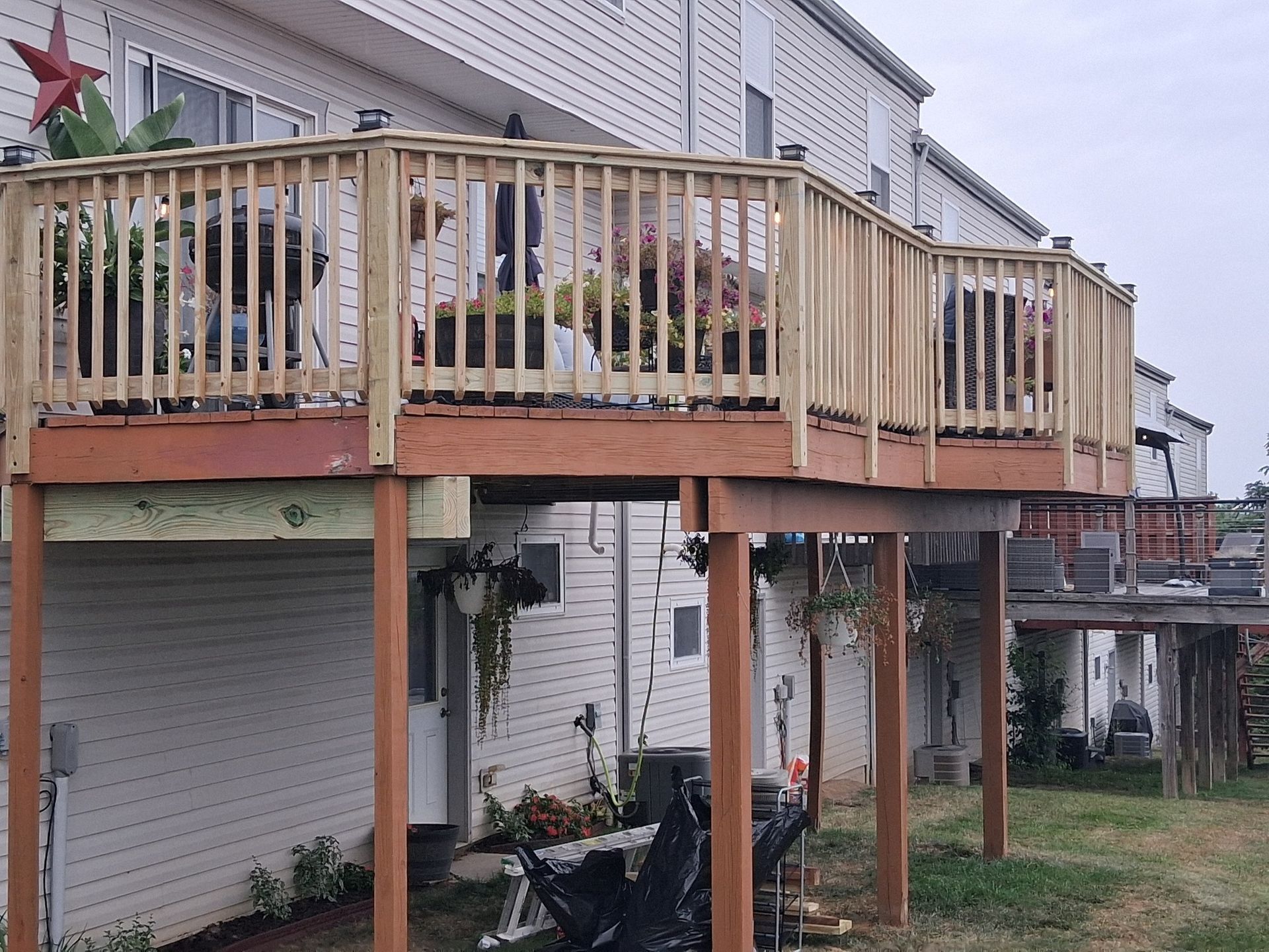 Wooden deck on the back of a white house with patio furniture and lattice skirting over the ground