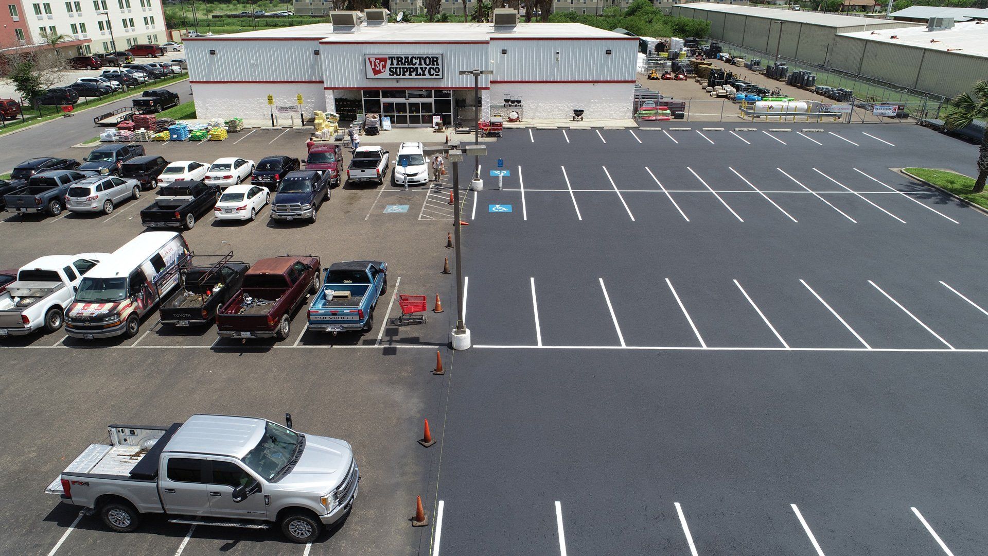 An aerial view of a Salvation Army store parking lot showing an area recently paved and striped next to an older section.