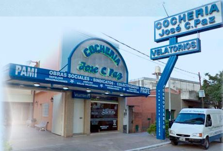 Funeraria Cochería José C. Paz con letrero azul. Una furgoneta blanca está estacionada cerca.