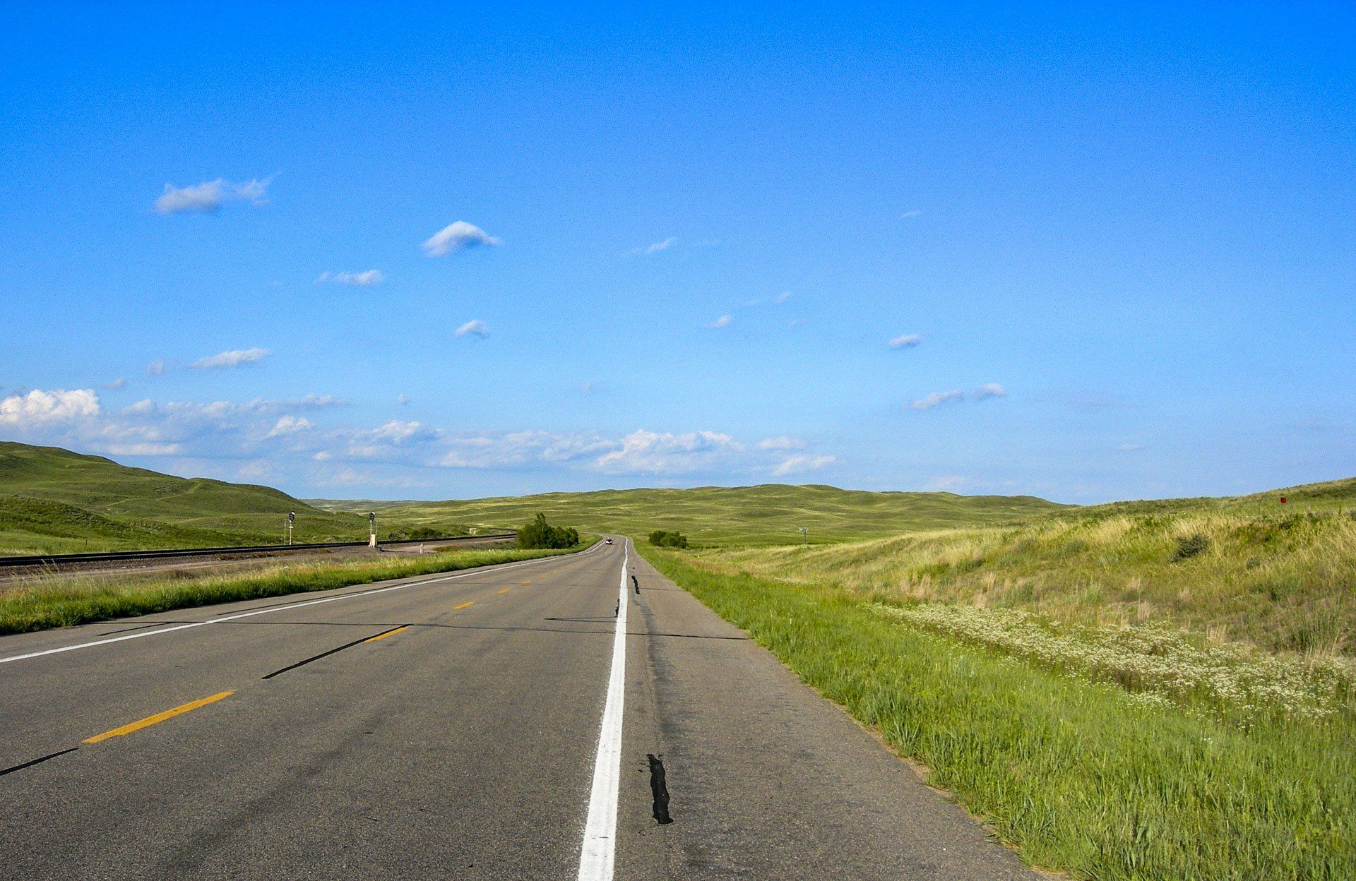 A road going through the Sandhills with a blue sky in the background.