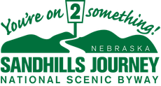 Green logo for Nebraska Sandhills Journey National Scenic Byway; signpost with