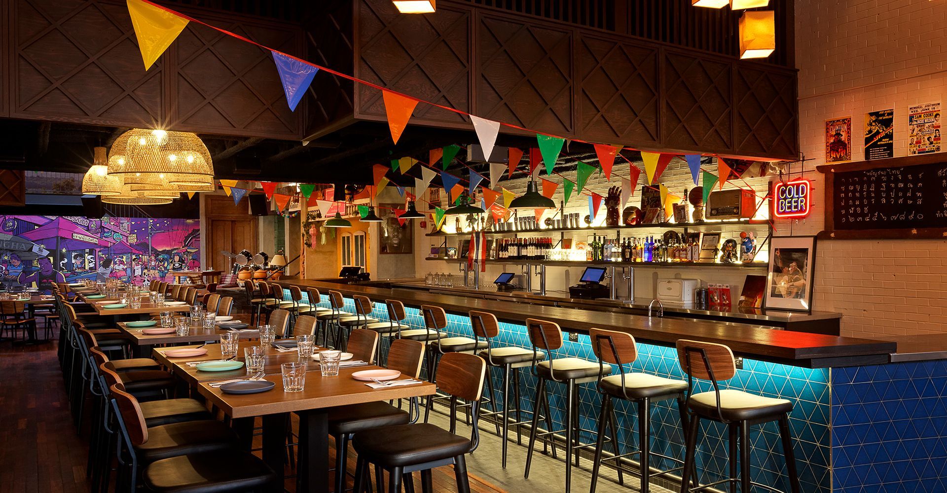 A restaurant with tables and chairs and a long bar