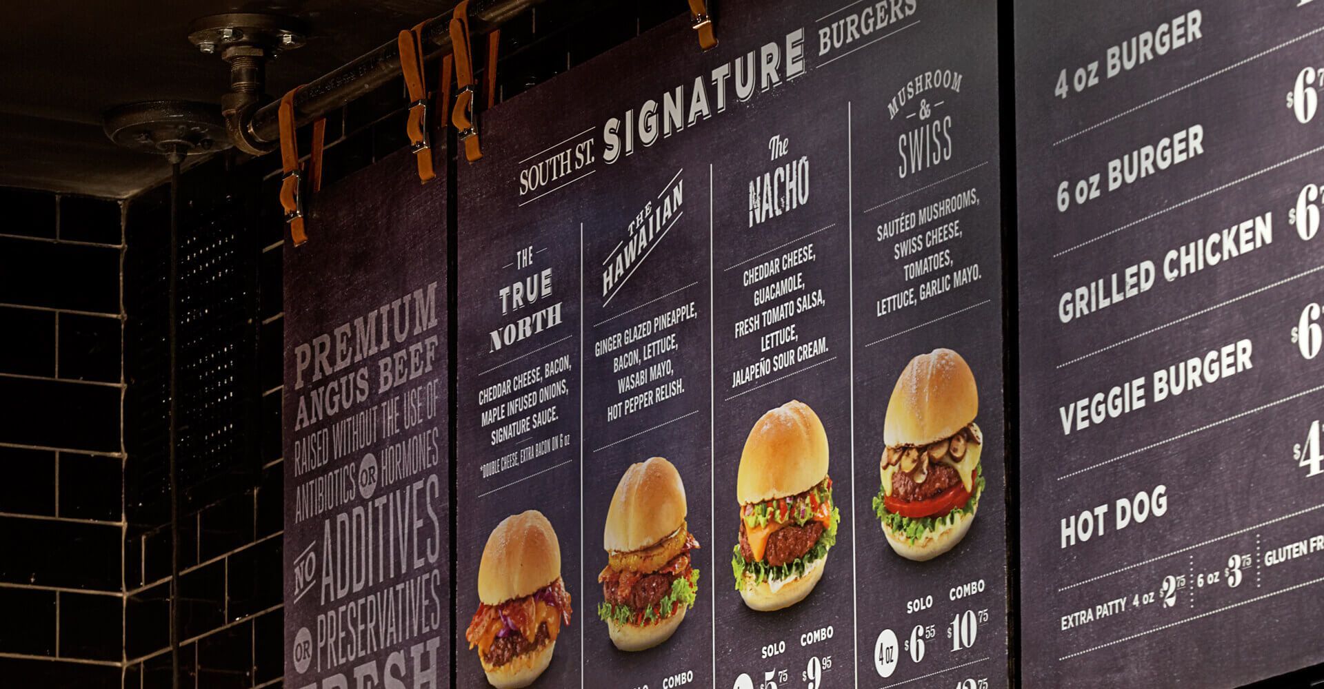 A chalkboard menu with a variety of burgers on it.
