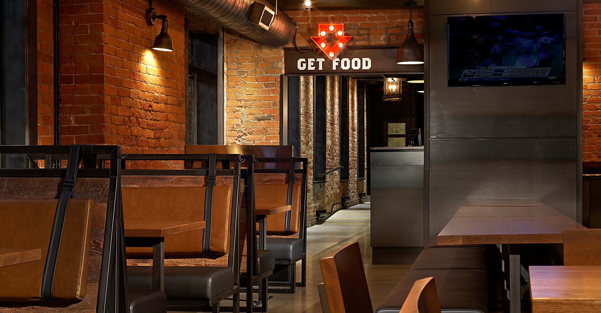 A restaurant with tables and chairs and a sign that says get food.