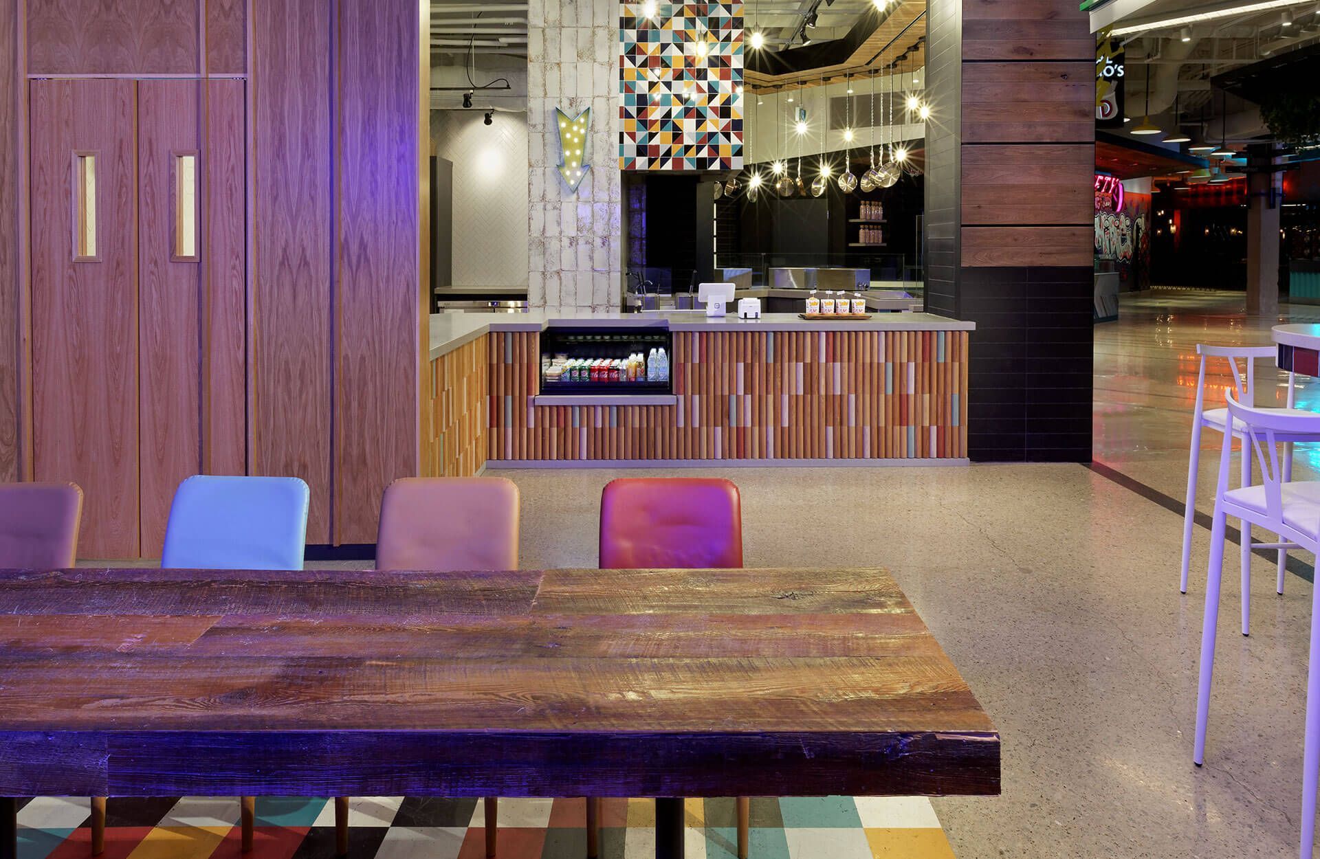 A restaurant with a wooden table and chairs and a counter.