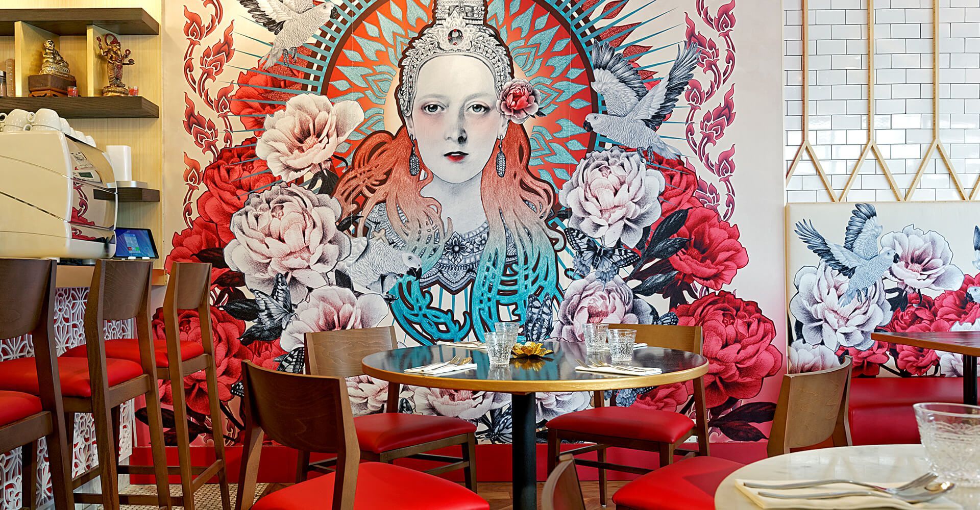 A restaurant with tables and chairs and a mural on the wall.