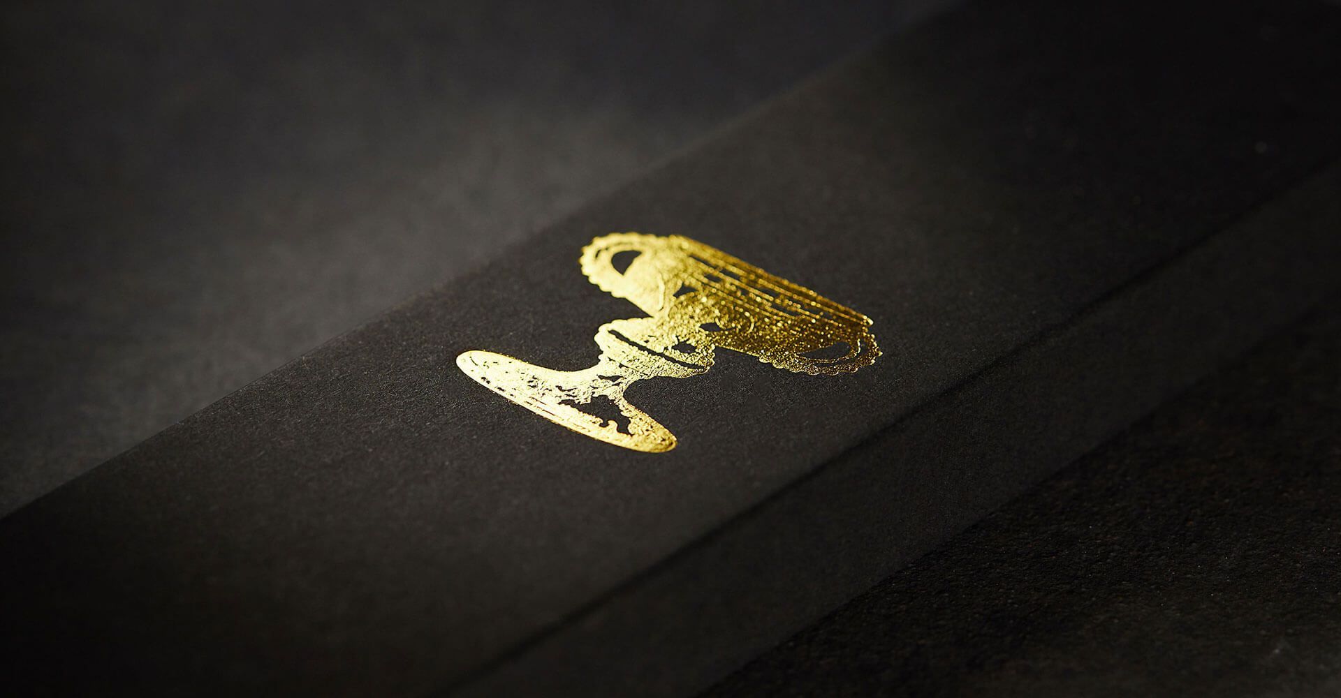 A close up of a black box with a gold logo on it.