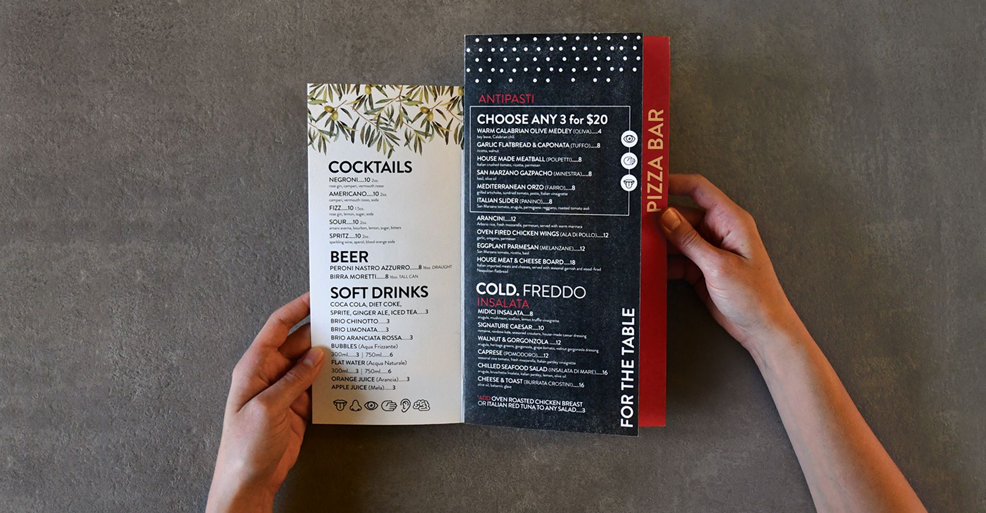A person is holding a menu for a restaurant called pizza bay