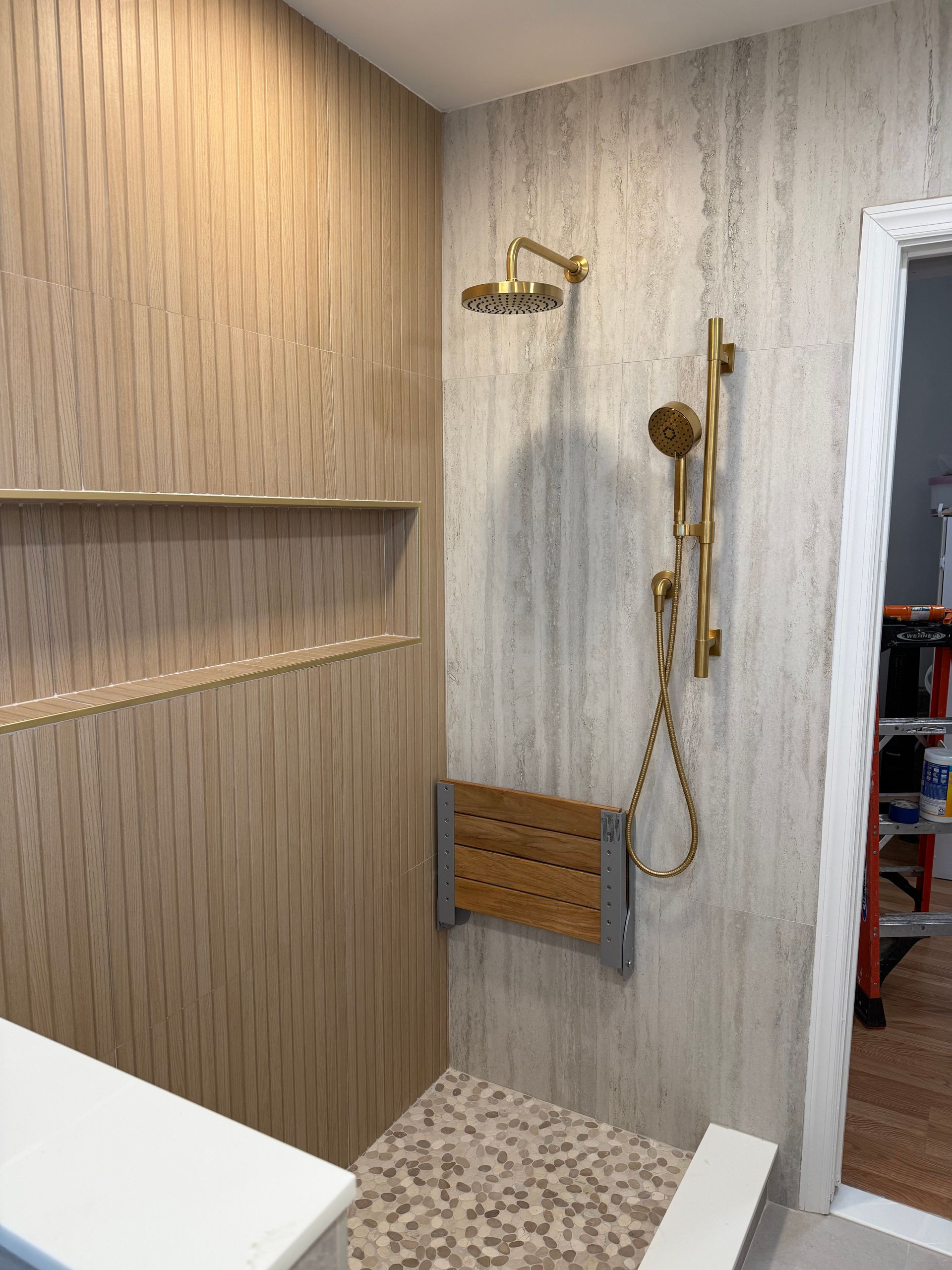 Modern bathroom with wood vanity, shower, and frosted window under recessed lights