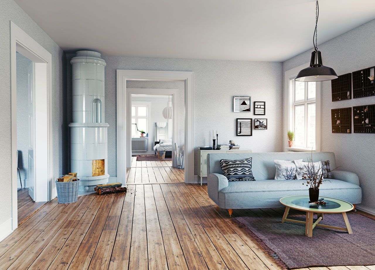 Cozy living room with fireplace, light blue sofa, wooden floor, and a small round table with plants.