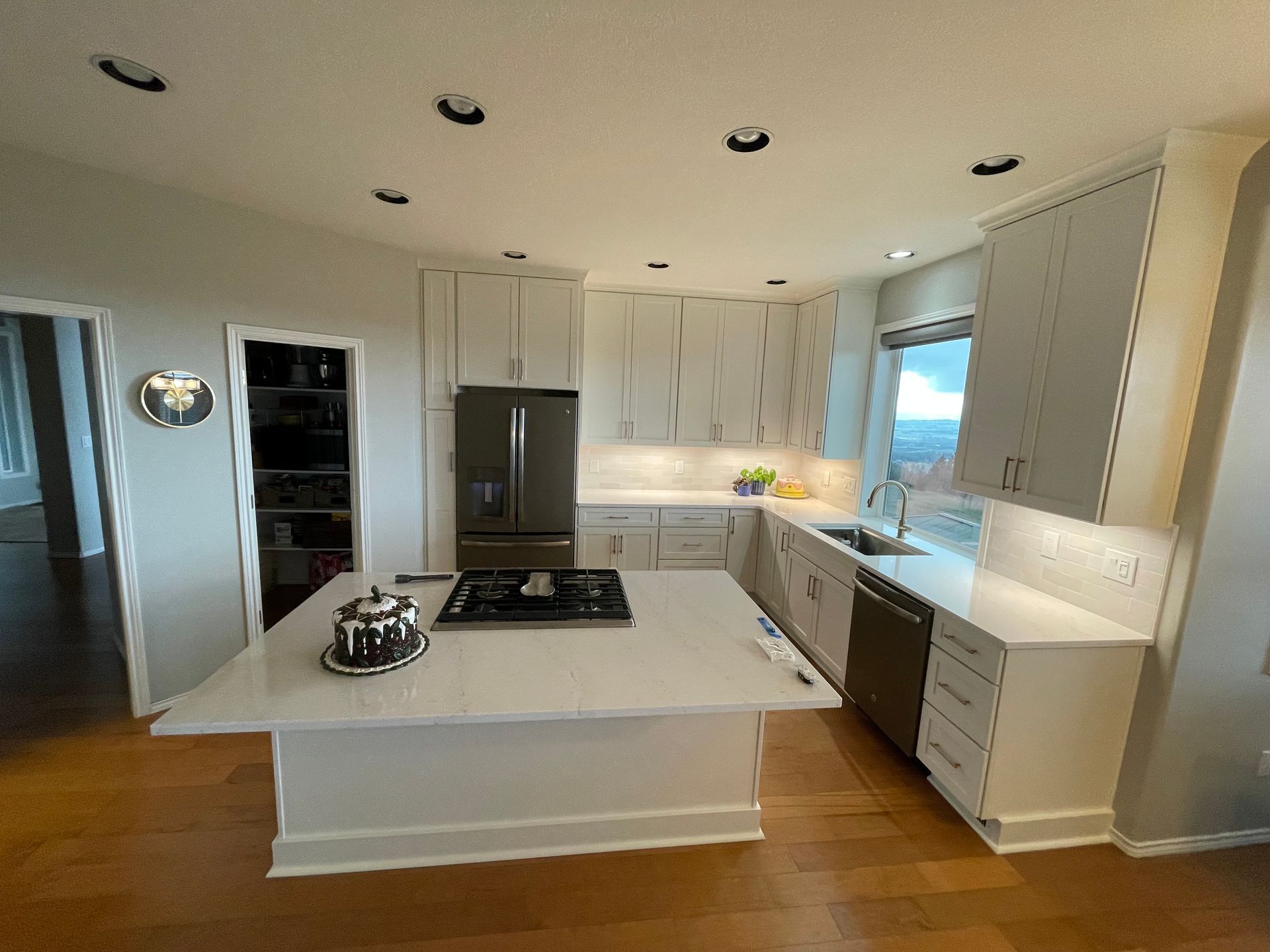White Shaker Kitchen With Quartz Countertops and Tile Backsplash
