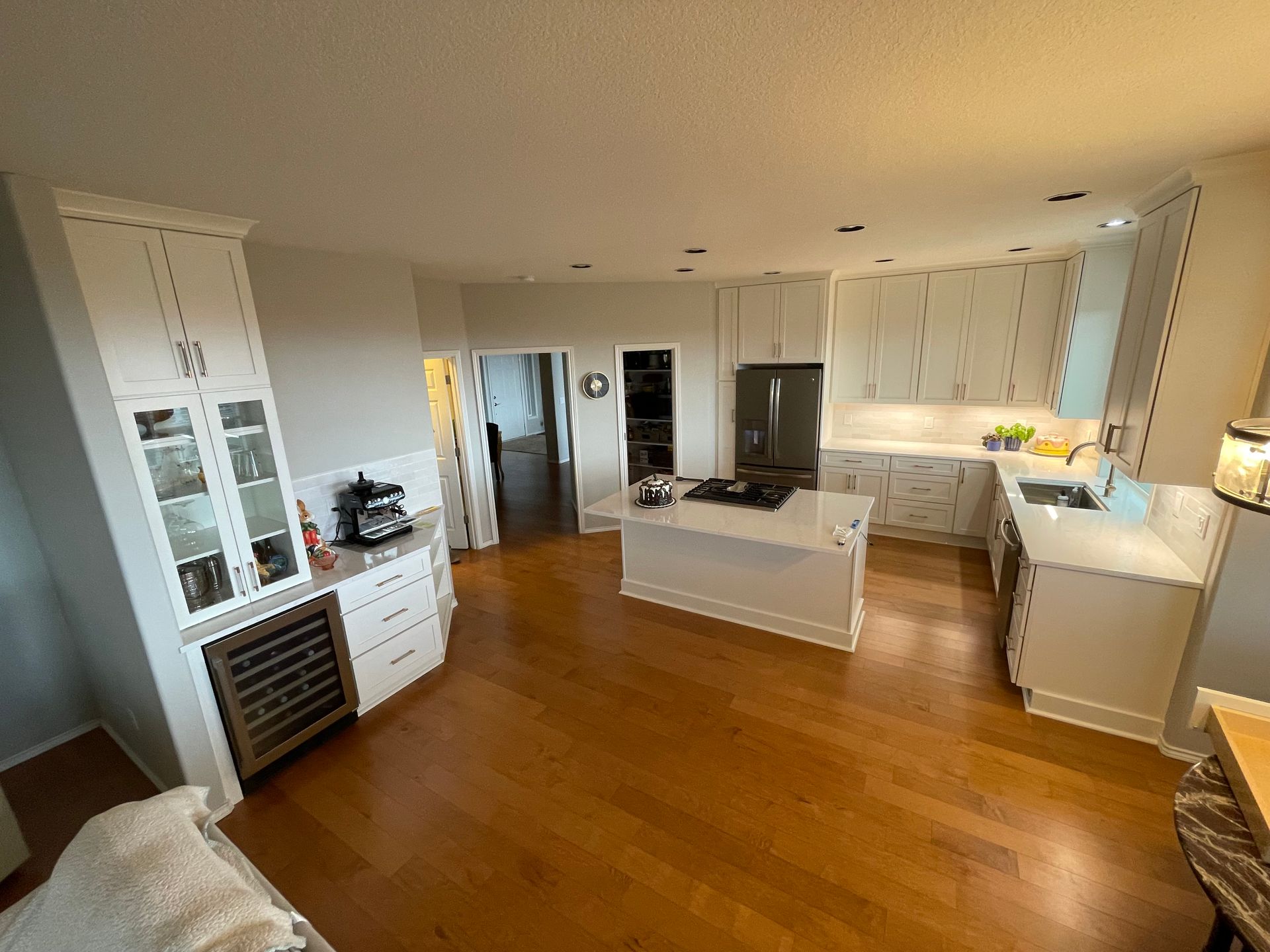 White Shaker Kitchen Wide Angle Overview With Tile Backsplash, Can Lighting, Wine Fridge and Quartz Countertops