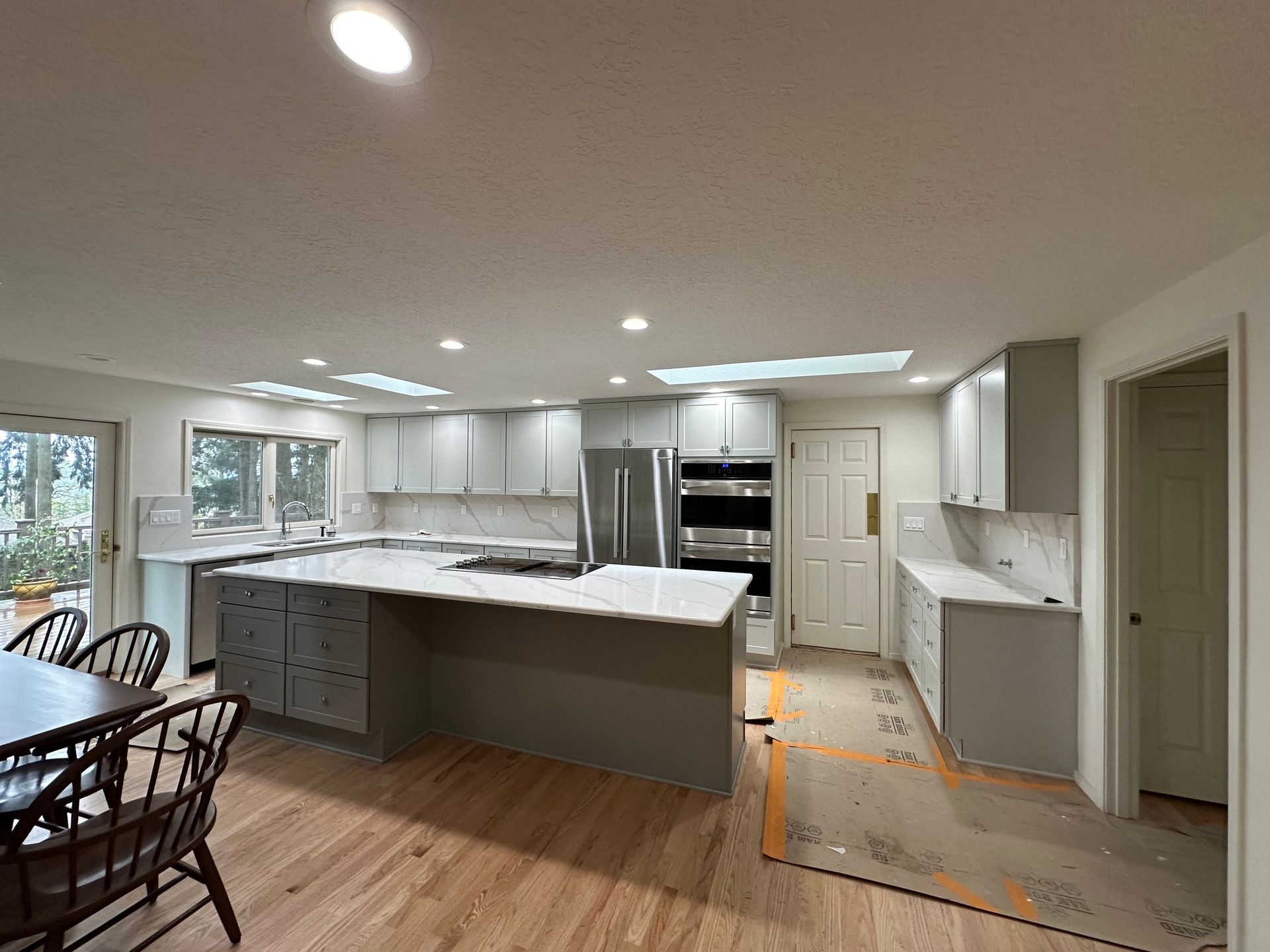 A kitchen with white cabinets and a large island in the middle of the room.
