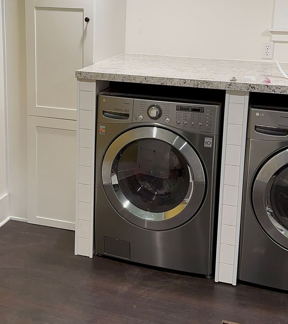 A washer and dryer are sitting next to each other in a laundry room.