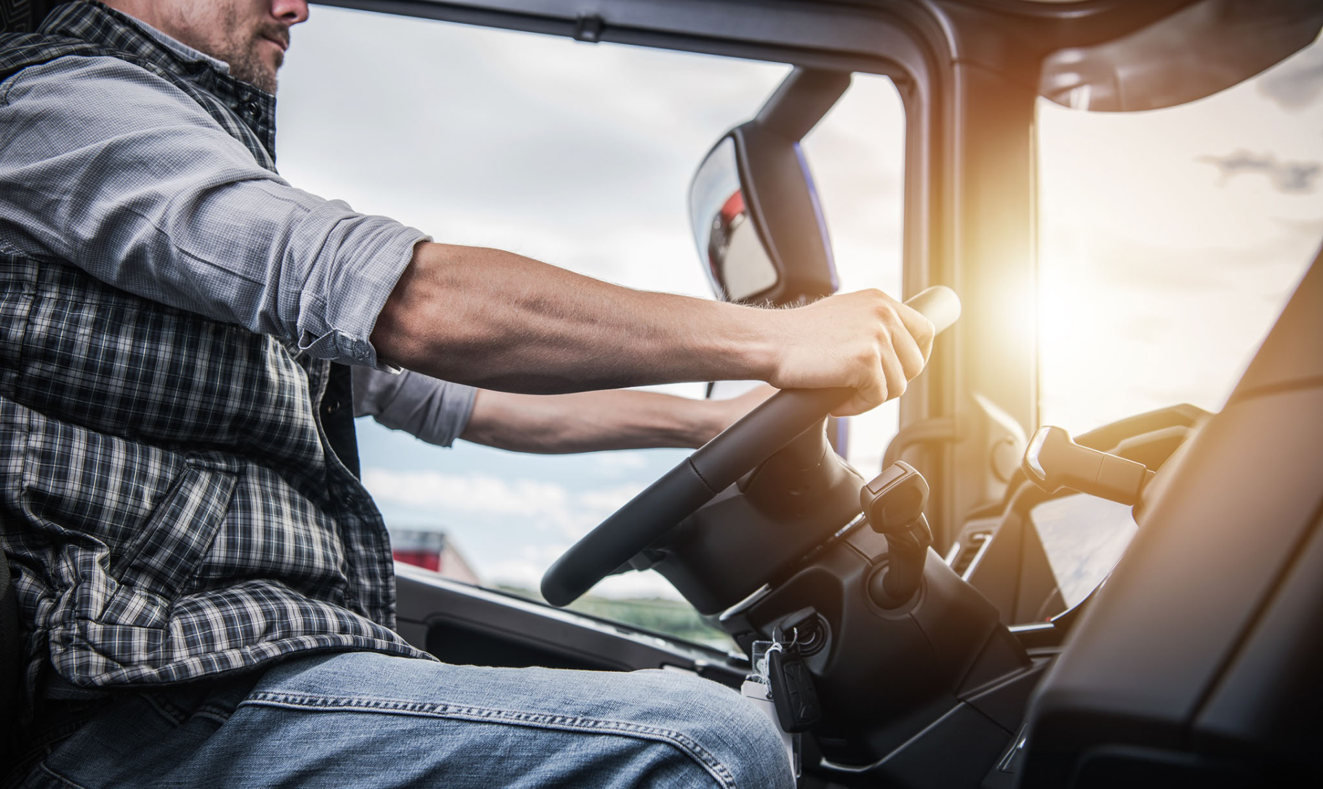 A man is driving a semi truck on a highway.