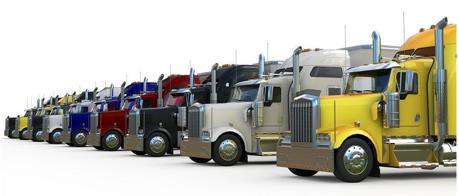 A row of semi trucks of different colors are parked in a row.