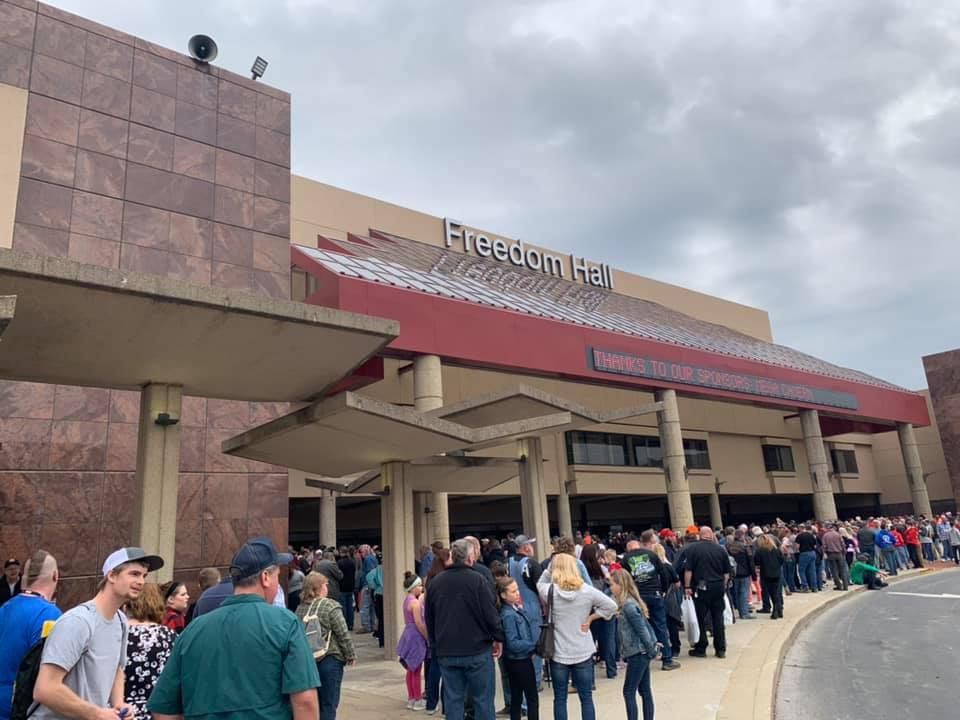 A large group of people are standing outside of a building.