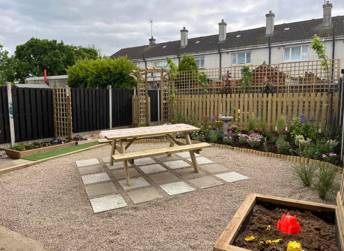 A backyard with a picnic table and a sandbox.