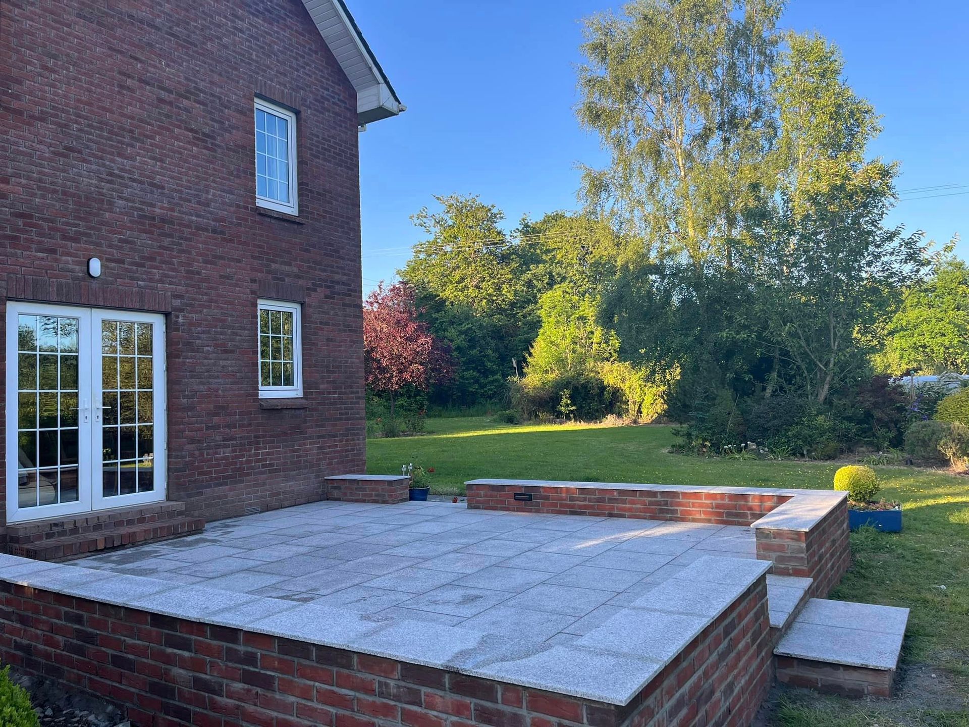 A brick house with a patio in front of it.